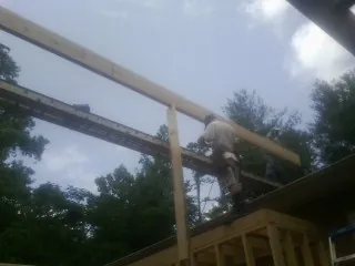 Carpenter setting a ridge beam over a new addition frame — Ice Dam Removal by Roofing Brothers in Turtletown