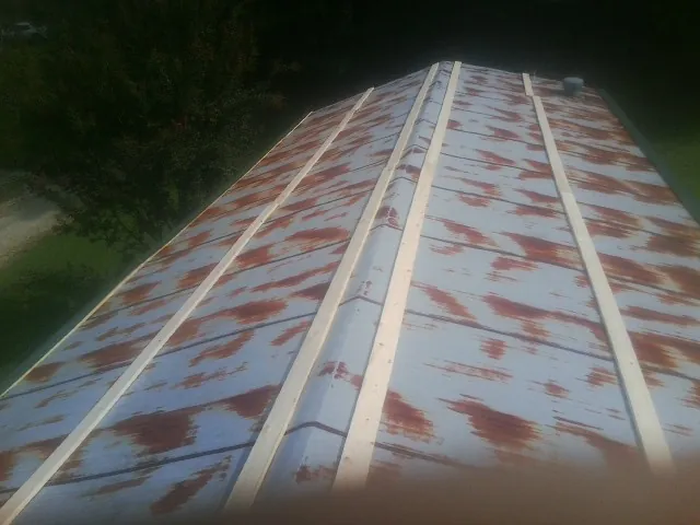 Rusted metal roof panels with new wood purlins before replacement — Storm Damage Roof Repair in Turtletown by Roofing Brothers